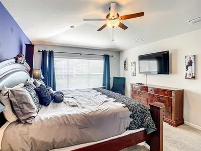 a bedroom with a bed and a ceiling fan at Windsor Hills Themed Home Pool Spa 2.5mi Disney in Orlando
