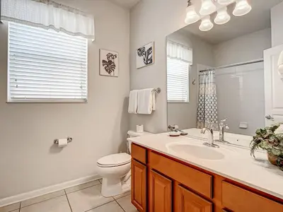 a bathroom with a sink and a toilet and a mirror at Windsor Hills Themed Home Pool Spa 2.5mi Disney in Orlando
