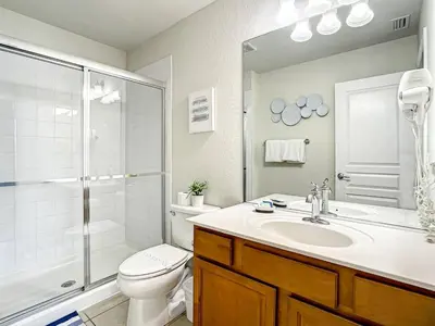 a bathroom with a toilet and a sink and a shower at Windsor Hills Themed Home Pool Spa 2.5mi Disney in Orlando