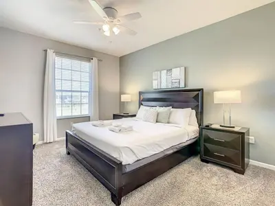 a bedroom with a large bed with a ceiling fan at Windsor Hills Themed Condo, 2.5mi to Disney in Orlando