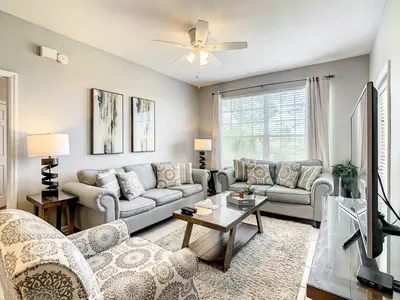 a living room with a couch and a tv at Windsor Hills Themed Condo, 2.5mi to Disney in Orlando