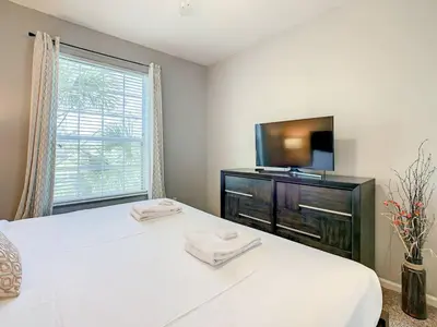 a bedroom with a bed and a flat screen tv at Windsor Hills Themed Condo, 2.5mi to Disney in Orlando