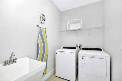 a laundry room with a washer and dryer next to a sink at Stylish Home With Private Pool, Themed And Game Room With Waterpark & Resort Access Near Disney At Encore Resorts Reunion - 300Bu in Kissimmee