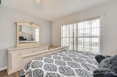 a bedroom with a bed and a mirror and a window at 4 Mi to Disney Spacious Retreat with Pool and Yard! in Kissimmee