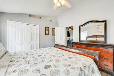 a bedroom with a bed with a dresser and a mirror at 4 Mi to Disney Spacious Retreat with Pool and Yard! in Kissimmee