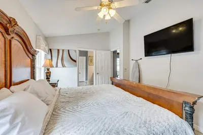 a bedroom with a large bed and a flat screen tv at 4 Mi to Disney Spacious Retreat with Pool and Yard! in Kissimmee