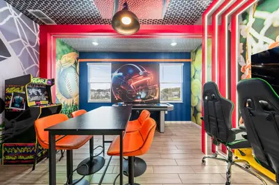 a dining room with a helmet mural on the wall at Big Family Home with Game Room Sleeps 28 BLV104 in Kissimmee