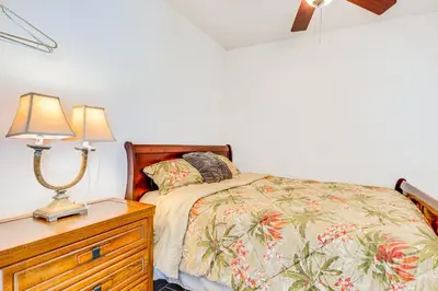 a bedroom with a bed and a dresser with two lamps at Orlando-Area Family Oasis with Lanai, Pool and Yard in Orlando