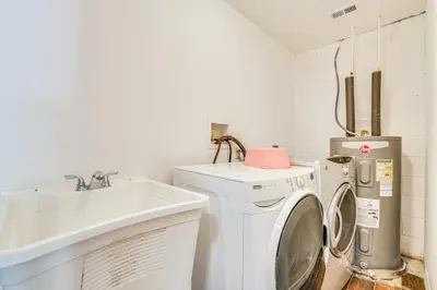 a laundry room with a washing machine and a sink at Orlando-Area Family Oasis with Lanai, Pool and Yard in Orlando