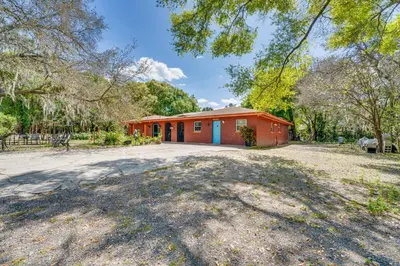 a red barn with a driveway in front of it at Orlando-Area Family Oasis with Lanai, Pool and Yard in Orlando