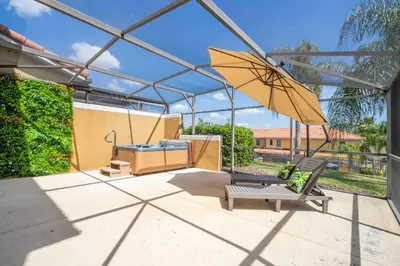 a patio with a swing and an umbrella at Perfect Themed 3 BD Hot tub renovated - 3013 in Kissimmee