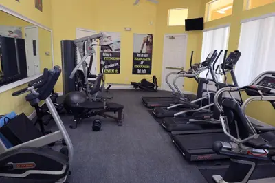a gym with several treadmills and exercise bikes at UniDisL 3Br3B near Disney quiet resort community, pool, private hot tub, BBQ & games in Kissimmee