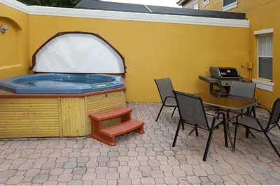 a patio with a hot tub and a table and chairs at UniDisL 3Br3B near Disney quiet resort community, pool, private hot tub, BBQ & games in Kissimmee