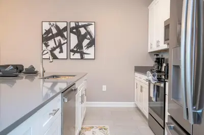 a kitchen with white cabinets and a stainless steel refrigerator at 4Bd Close to Disney with Pool at Storey Lake 2560 in Kissimmee