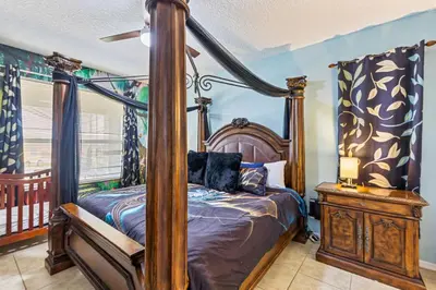 a bedroom with a four poster bed and a window at 7BDM Prvt Pool Villa - Gated Resort 10min to Disney in Kissimmee
