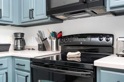 a kitchen with a black stove and blue cabinets at 5* House 5* Resort Orlando. Location location location in Orlando
