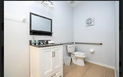 a white bathroom with a toilet and a mirror at 5* House 5* Resort Orlando. Location location location in Orlando