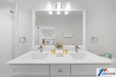 a white bathroom with two sinks and a large mirror at The Epic Toronto Vista Cay Orlando in Orlando