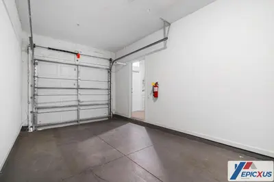 an empty garage with white walls and white garage doors at The Epic Toronto Vista Cay Orlando in Orlando