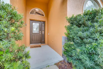 a front door of a house with bushes at Renovated Kissimmee Home - 10 Mi to Disney Springs in Kissimmee