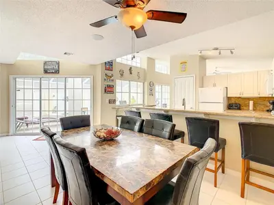 a kitchen and dining room with a table and chairs at Private Pool With Heat - Close to Disney! in Kissimmee