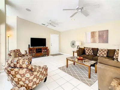 a living room with a couch and a tv at Private Pool With Heat - Close to Disney! in Kissimmee