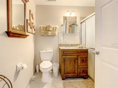 a bathroom with a toilet and a sink and a mirror at Private Pool With Heat - Close to Disney! in Kissimmee