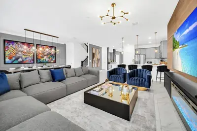 a living room with a gray couch and blue chairs at Amazing 9 Bedroom Lake View in Kissimmee