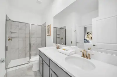 a bathroom with two sinks and a shower and a toilet at Amazing 9 Bedroom Lake View in Kissimmee