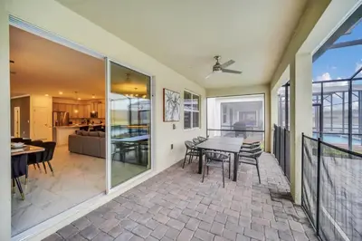 a dining room and living room with a table and chairs at Amazing 9 Bedroom Lake View in Kissimmee