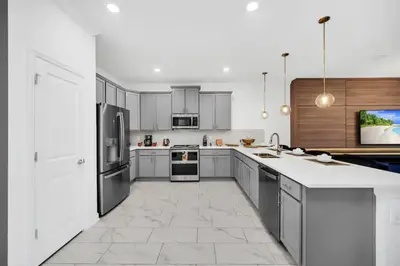 a large kitchen with white cabinets and appliances at Amazing 9 Bedroom Lake View in Kissimmee