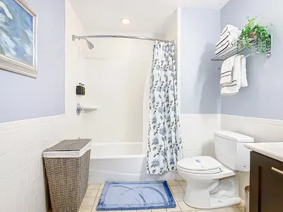 a white bathroom with a toilet and a shower at 1Bed/1Bath Pet Friendly Condo at the Melia in Orlando