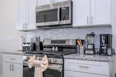 a kitchen with a stove and a microwave at Amazing 2024 Villa 5 min to Disney in Orlando