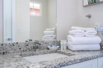 a bathroom with a sink and a pile of towels at Amazing 2024 Villa 5 min to Disney in Orlando