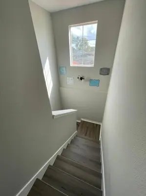 a hallway with a staircase with a window and a stair case at 4 Bedroom 3 Bathroom Terra Verde 111PB in Kissimmee