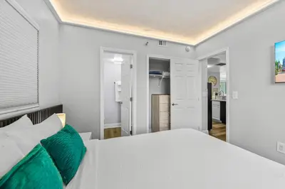 a bedroom with a white bed with green pillows at Exclusive Ground floor Apartment with Balcony in Orlando