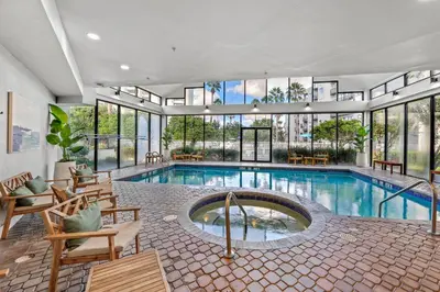 a large indoor pool with chairs and a large building at Exclusive Ground floor Apartment with Balcony in Orlando