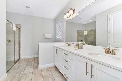 a white bathroom with two sinks and a shower at Lavish Home Near Disney With Media, Game & Theme Rooms With Waterpark & Resort Access At Encore Resorts Reunion - 520Bu in Kissimmee
