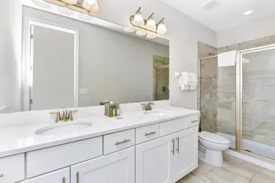 a white bathroom with two sinks and a toilet at Lavish Home Near Disney With Media, Game & Theme Rooms With Waterpark & Resort Access At Encore Resorts Reunion - 520Bu in Kissimmee