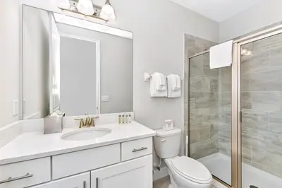 a white bathroom with a toilet and a shower at Lavish Home Near Disney With Media, Game & Theme Rooms With Waterpark & Resort Access At Encore Resorts Reunion - 520Bu in Kissimmee
