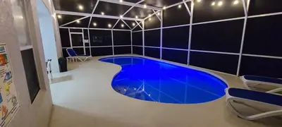 a large blue pool in a room with black tiles at Home Close to Disney Parks/Amazing Private Pool in Orlando