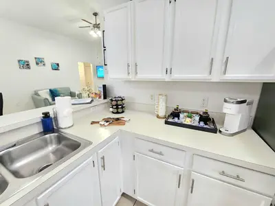 a kitchen with white cabinets and a sink at Home Close to Disney Parks/Amazing Private Pool in Orlando