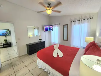 a bedroom with a red bed with a bow on it at Home Close to Disney Parks/Amazing Private Pool in Orlando