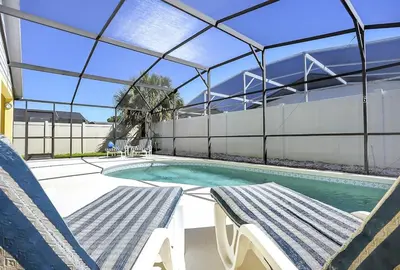 a swimming pool with two chairs and a bench in a house at 7832 Cozy Gem at Indian Ridge with Pool in Orlando