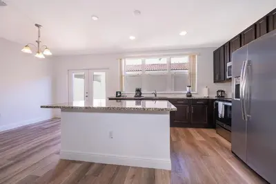 a kitchen with a white counter top and a refrigerator at Resort-Style Home in gated community with ammenities close to MCO and Parks! in Kissimmee