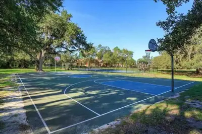a basketball court in a park with a basketball hoop at Resort-Style Home in gated community with ammenities close to MCO and Parks! in Kissimmee
