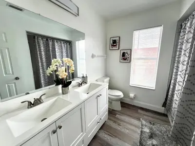 a bathroom with two sinks and a toilet and a mirror at Buena Ventura Escape in Kissimmee