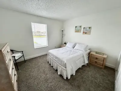 a white bedroom with a bed and a window at Buena Ventura Escape in Kissimmee
