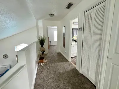 a hallway of a home with a staircase and a table at Buena Ventura Escape in Kissimmee