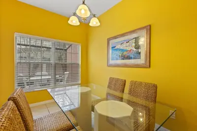 a dining room with a table and chairs and a window at Shvck3 - Coral Cay Resort #3 - 4 Bed 3 Baths Townhome in Kissimmee